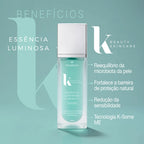 Dermafórmula Melhor Farmácia de Manipulação na Baixada Santista | Infográfico de indicação da Essência Luminosa K-Beauty. Apresenta o frasco de vidro do serum sobre uma plataforma cilíndrica turquesa. Ao lado, o texto detalha as indicações: Para todos os tipos de pele, Ideal para usar após a limpeza e Prepara a pele para os próximos produtos. A embalagem destaca os ingredientes: Ginseng Branco Fermentado, Ginseng Vermelho Fermentado e Vitis Vinifera.